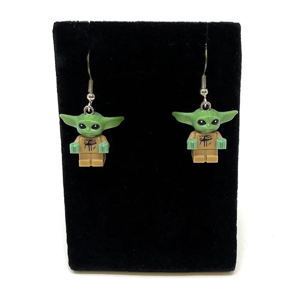 Two Grogu LEGO minifigure earrings with green heads, brown torsos, mint hands on silver hooks.