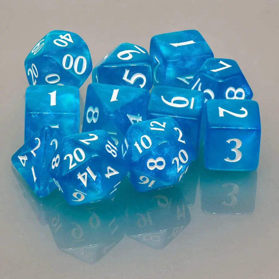 Sky blue Eclipse acrylic RPG dice set with 11 polyhedral dice from THE MIGHTY HOBBY SHOP, spread out showing various faces.