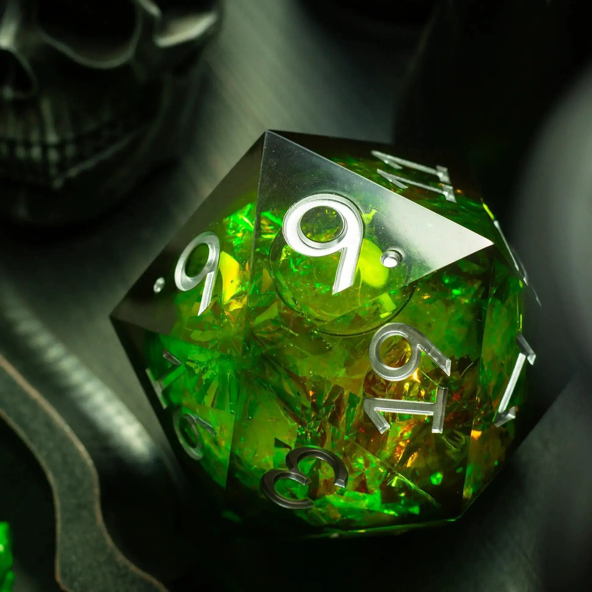 Large green resin D20 dice with liquid core from Runic Dice, displayed with its matching box on a flat surface.