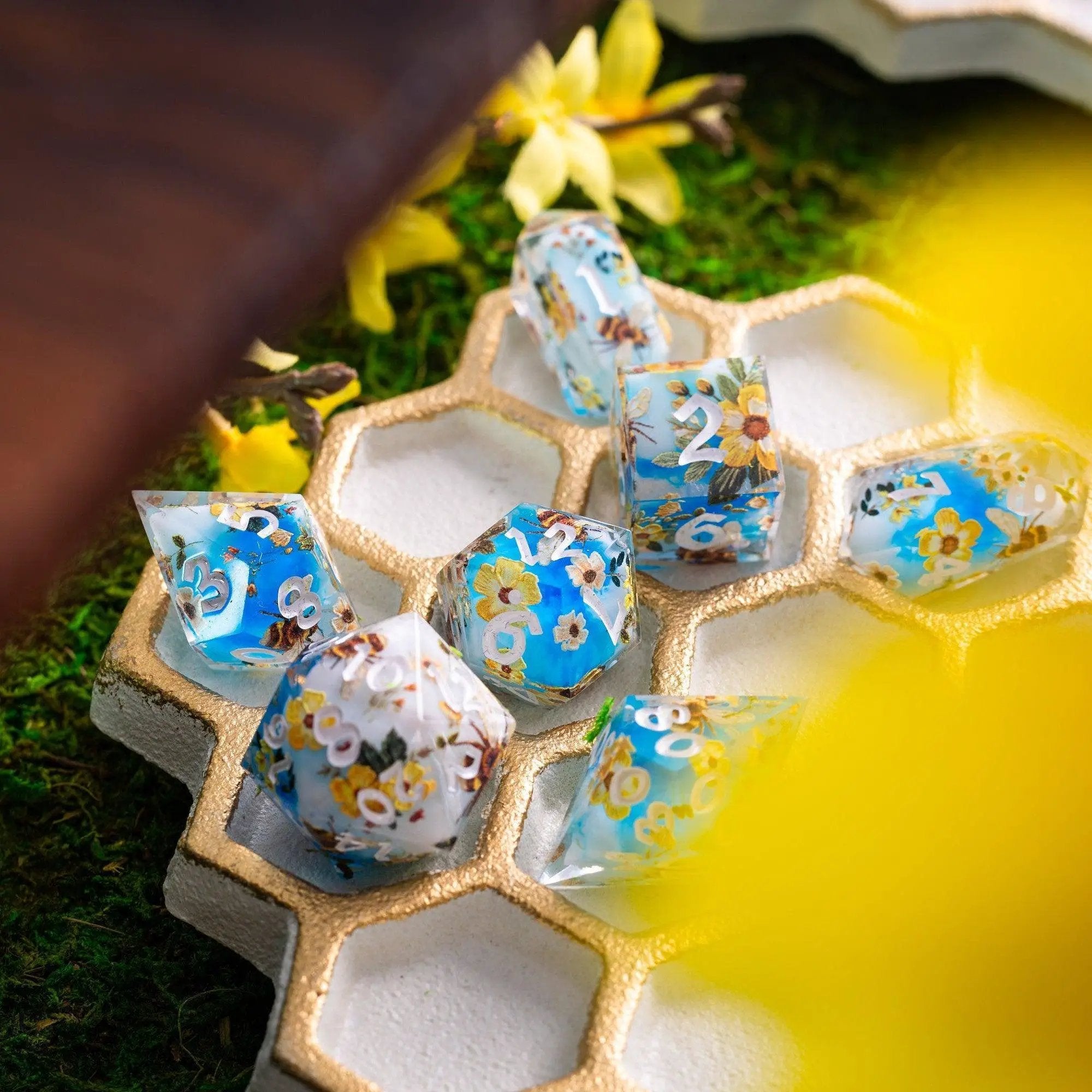 Handmade resin DND dice set featuring bees and flowers design by Runic Dice, close-up of colorful, detailed dice on a neutral background.