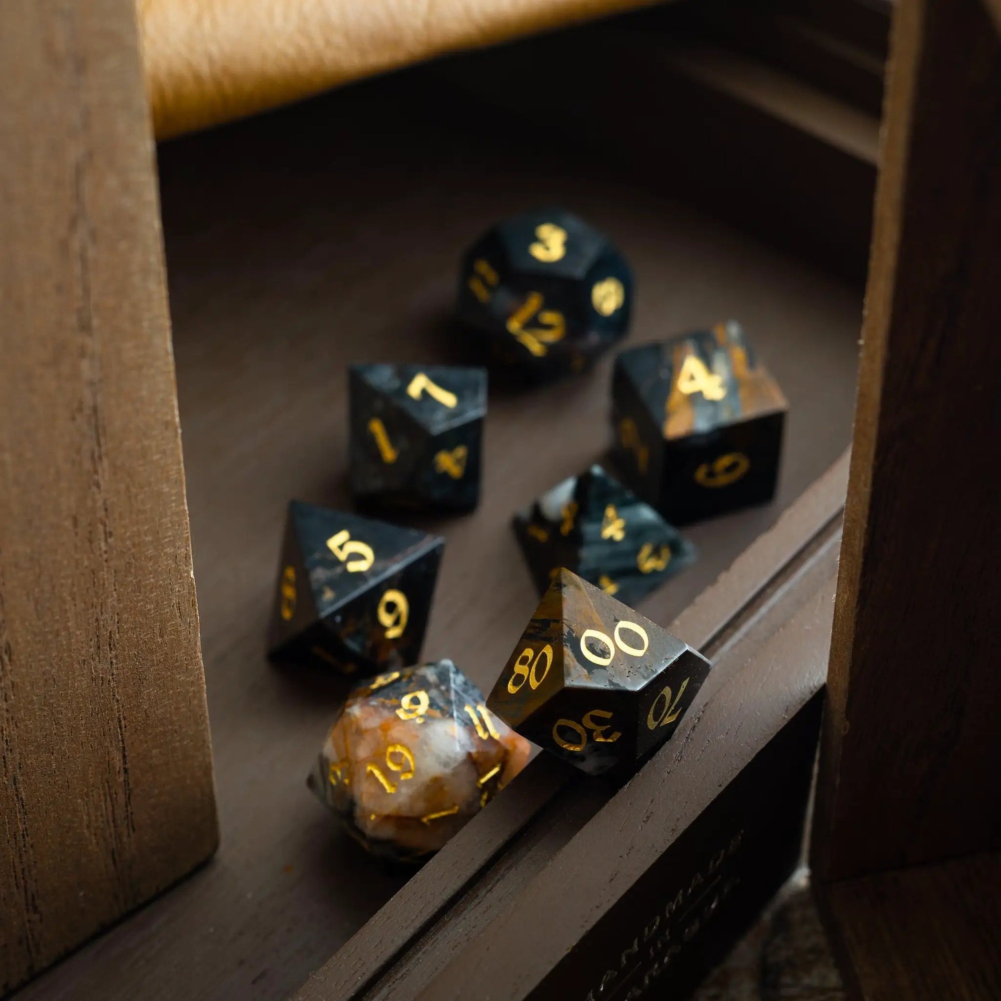 Black gemstone eagle eye DND dice set with hand-carved designs by Runic Dice, featuring polished, detailed gemstone dice.