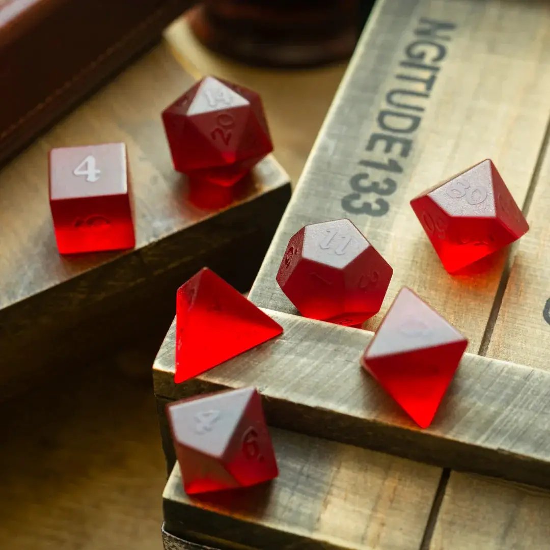 Blood red raised zircon glass gemstone DND dice set by Runic Dice, hand-carved with intricate detailing, ideal for tabletop gaming.