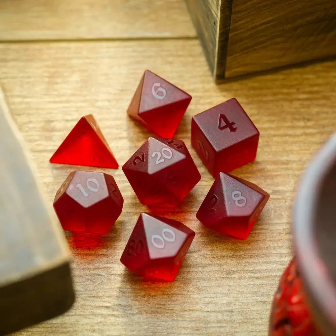 Blood red raised zircon glass gemstone DND dice set with hand-carved designs from Runic Dice, featuring multiple dice in the set.