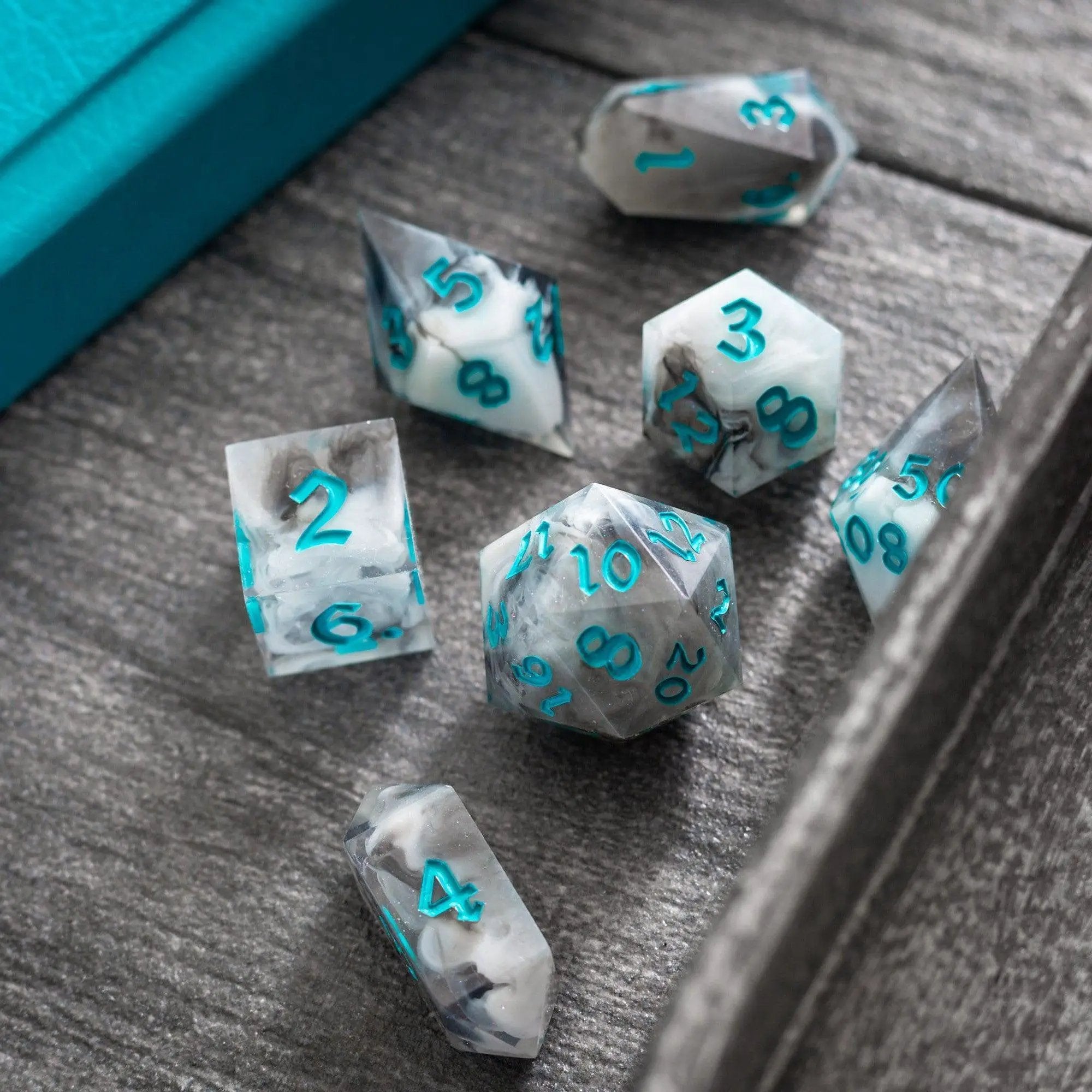 Blue cloud-themed handmade resin DND dice set by Runic Dice, featuring seven intricately designed colorful polyhedral dice.