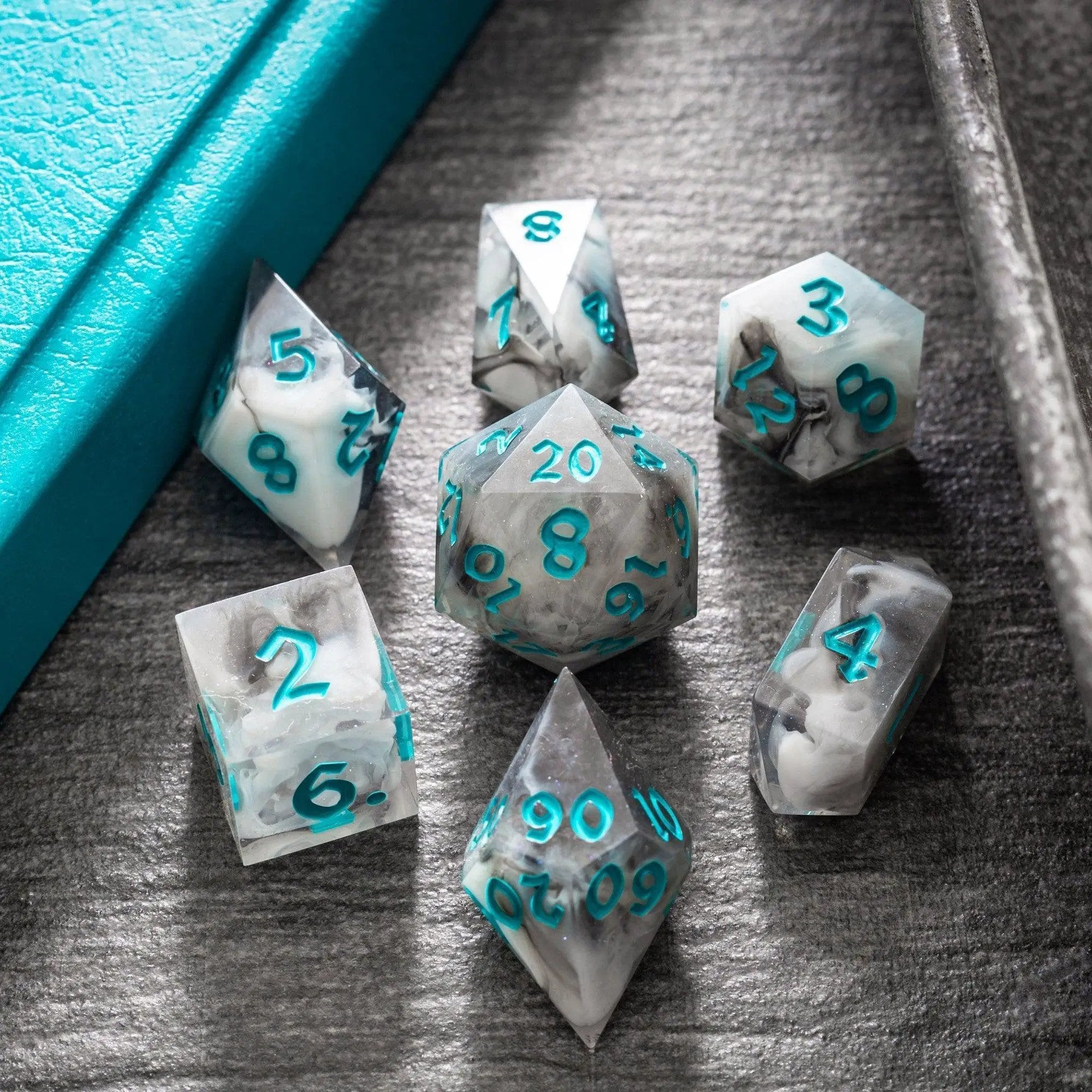Blue resin DND dice set featuring cloud patterns, handmade by Runic Dice, with multiple numbered dice for tabletop gaming.
