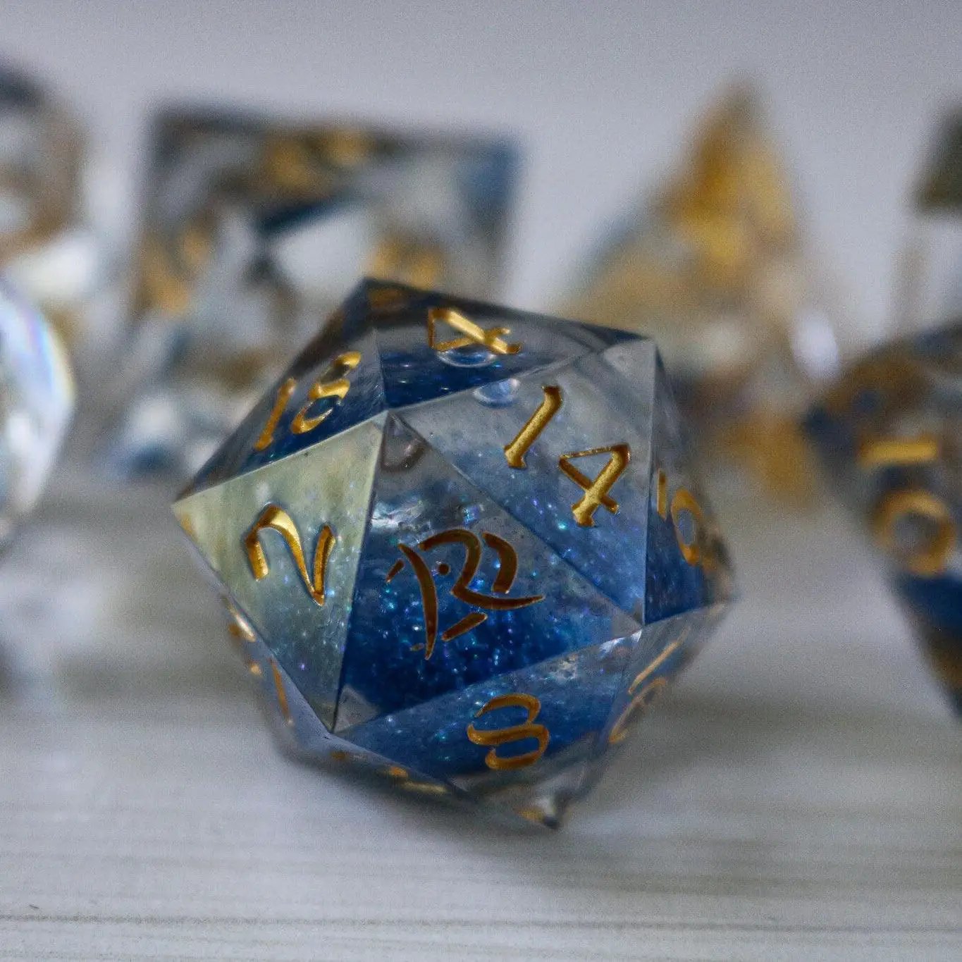 Blue glitter liquid core DND dice set by Runic Dice, handmade resin with sharp edges and vibrant sparkling design.