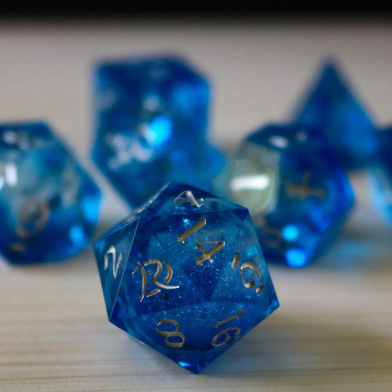 Blue glitter liquid core sharp edge resin DND dice set by Runic Dice, featuring handmade design and vibrant, sparkling details.