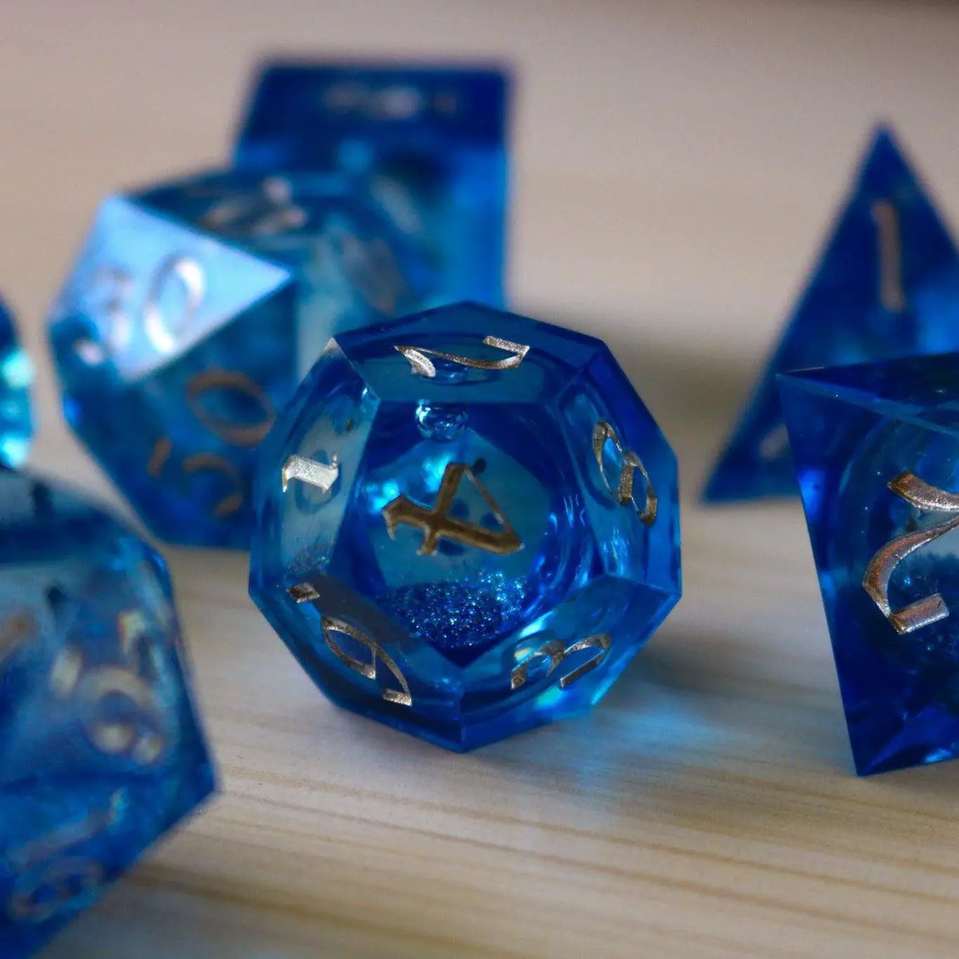 Blue glitter liquid core DND dice set with sharp edges, handmade resin design by Runic Dice.
