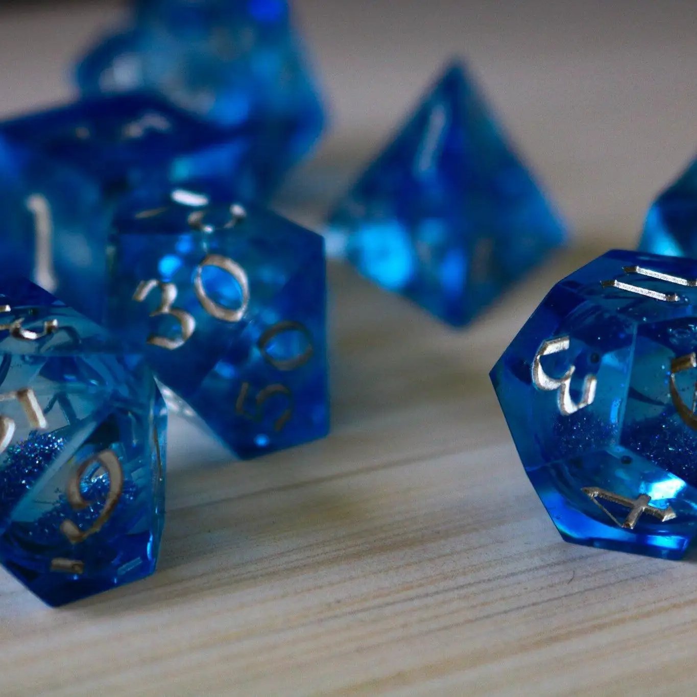 Blue glitter liquid core DND dice set by Runic Dice, featuring sharp edges and handmade resin design for tabletop gaming.