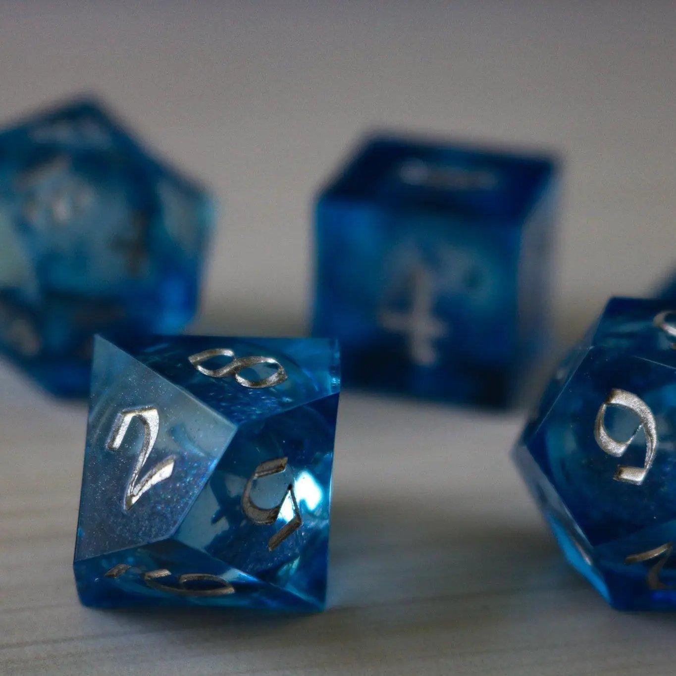 Blue glitter liquid core DND dice set with sharp edges, handmade resin design by Runic Dice.