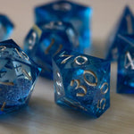 Blue glitter liquid core sharp edge handmade resin DND dice set by Runic Dice, featuring vibrant blue colors and intricate design.