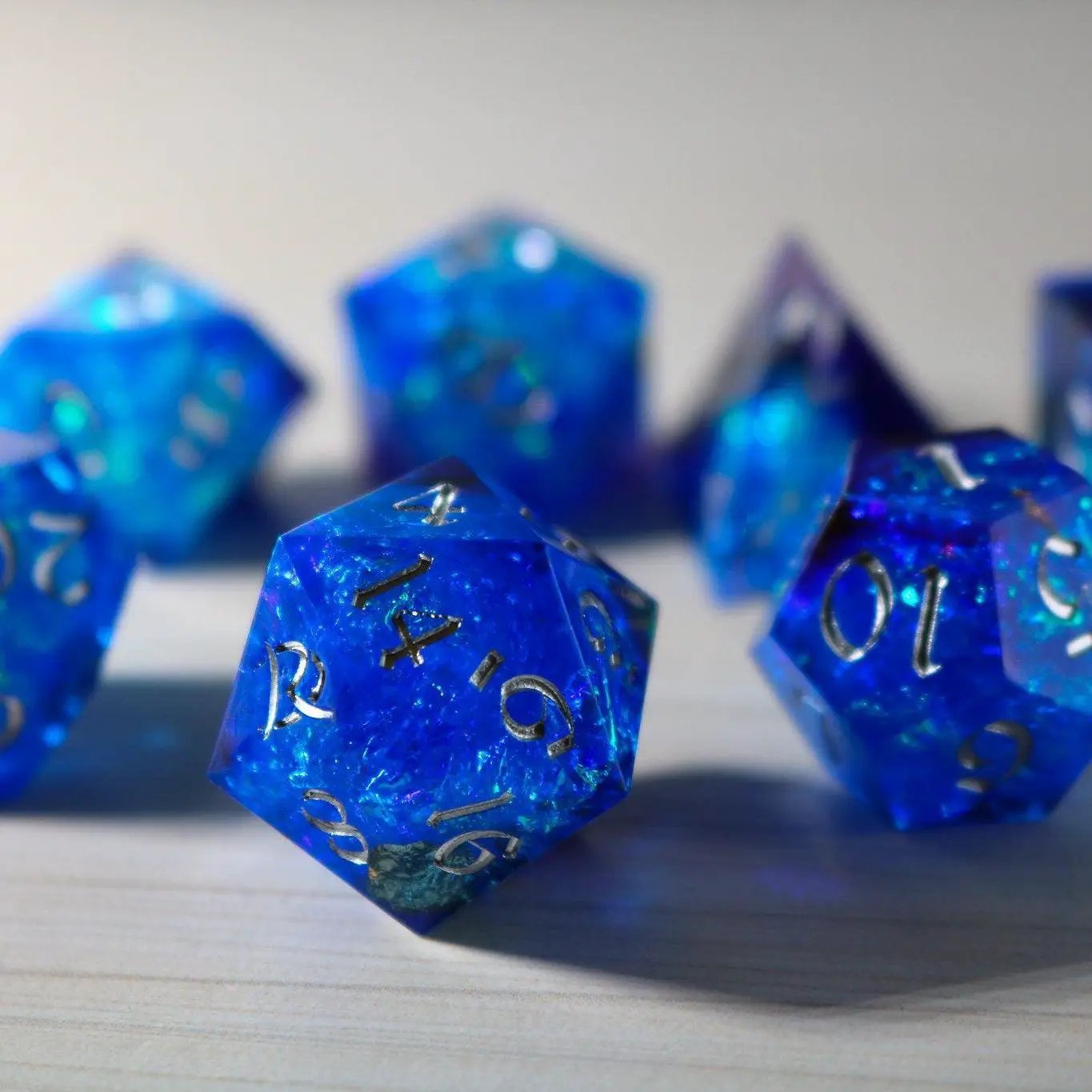 Blue handmade resin DND dice set with sharp edges, featuring a vibrant blue design from Runic Dice.