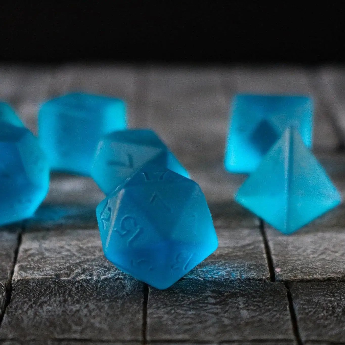 Blue zircon gemstone dice set by Runic Dice, hand-carved glass D&D dice with intricate blue zircon design.