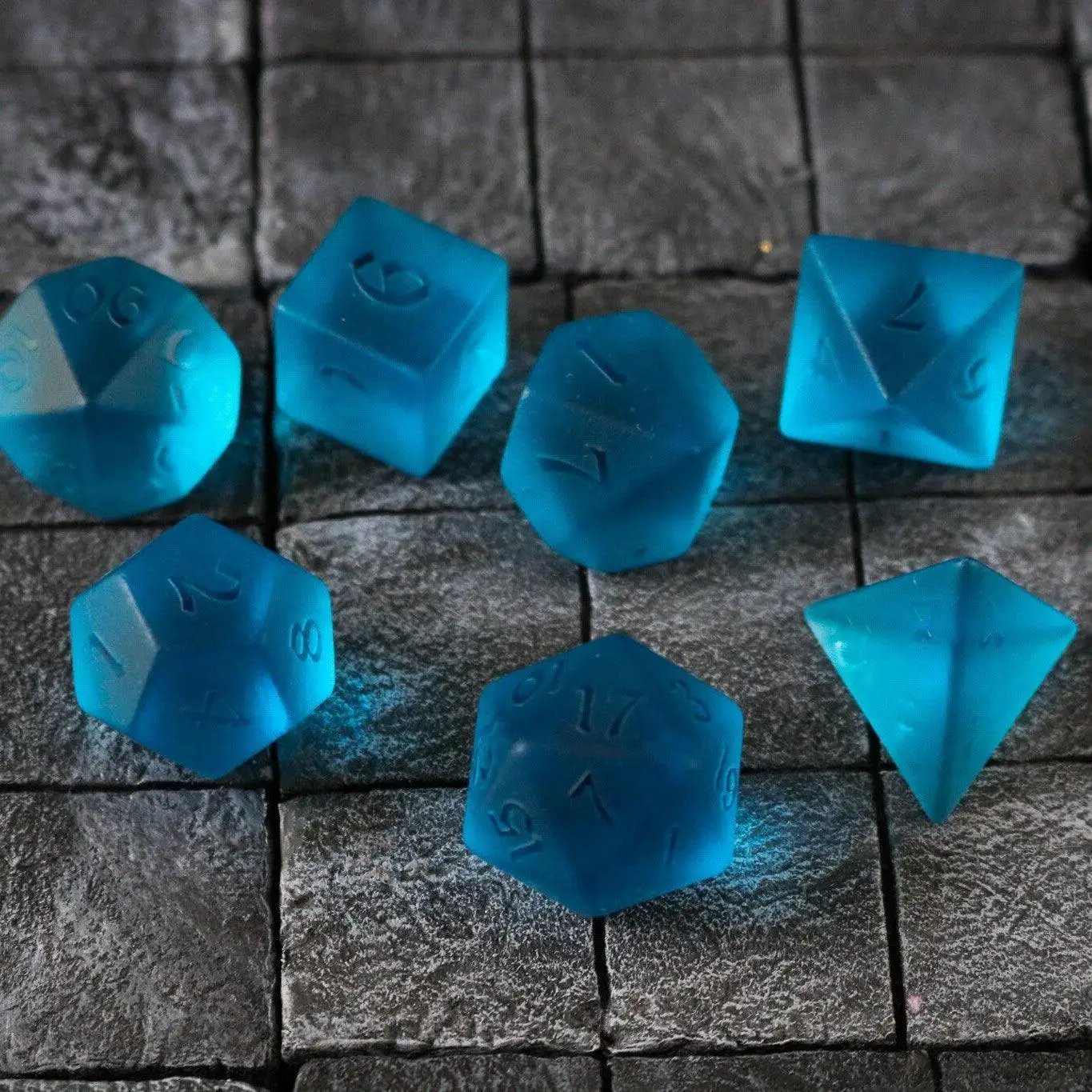 Blue zircon gemstone D&D dice set by Runic Dice, hand-carved glass set with six blue gemstone-shaped dice for tabletop gaming.