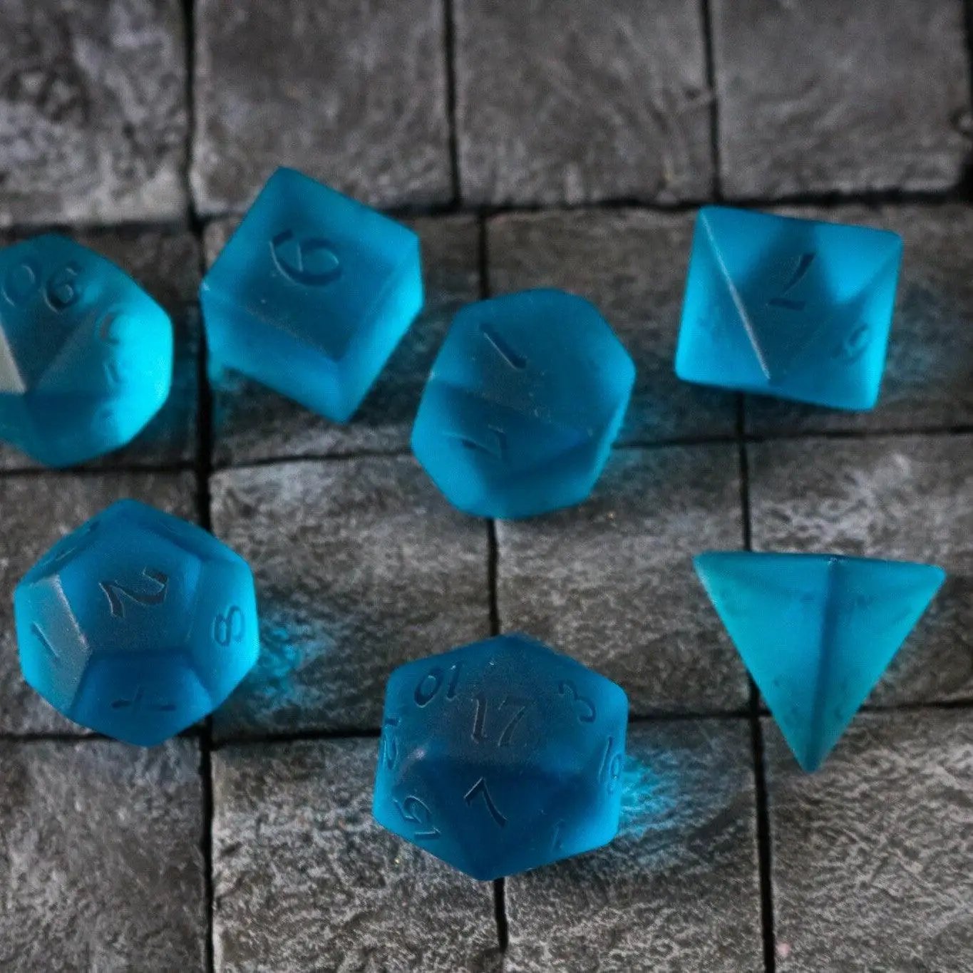 Blue zircon gemstone DND dice set with hand-carved glass design from Runic Dice, featuring seven blue zircon gemstone dice.