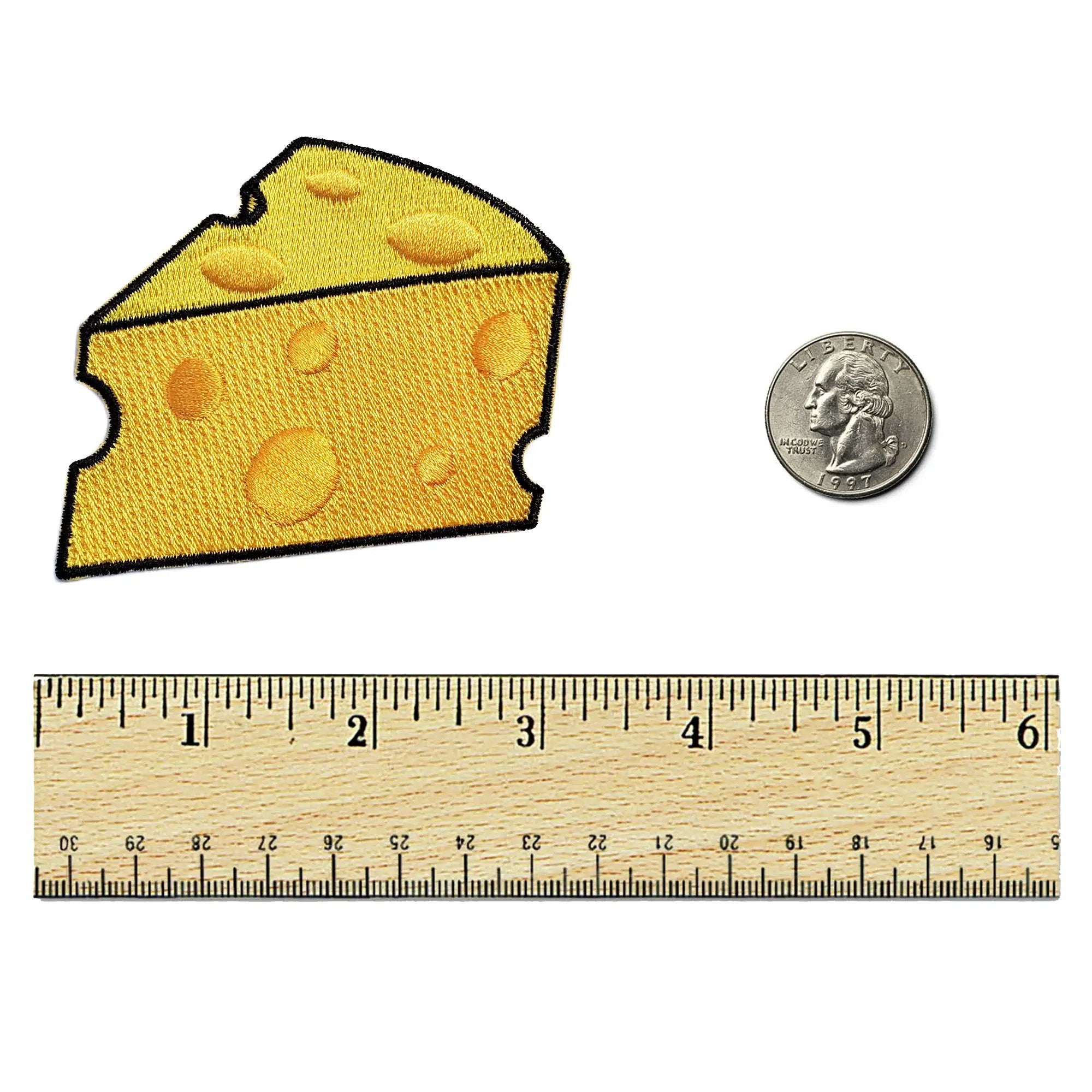 Kolorspun cheese slice patch attached to a ruler, showcasing the patch's design and size for clothing or accessories.