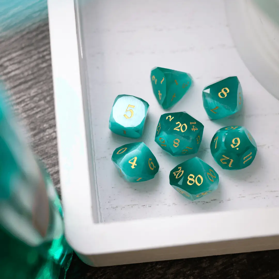 Runic Dice dwarf-cut aquamarine cat's eye gemstone DND dice set showing polished gemstone dice with intricate carvings and vibrant blue color.