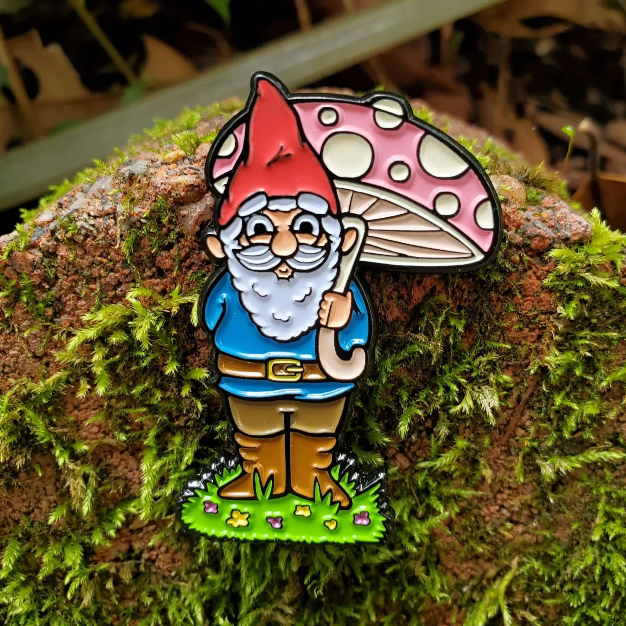 Kolorspun garden gnome enamel pin on moss background, featuring a whimsical gnome design perfect for pin collectors and outdoor decor.