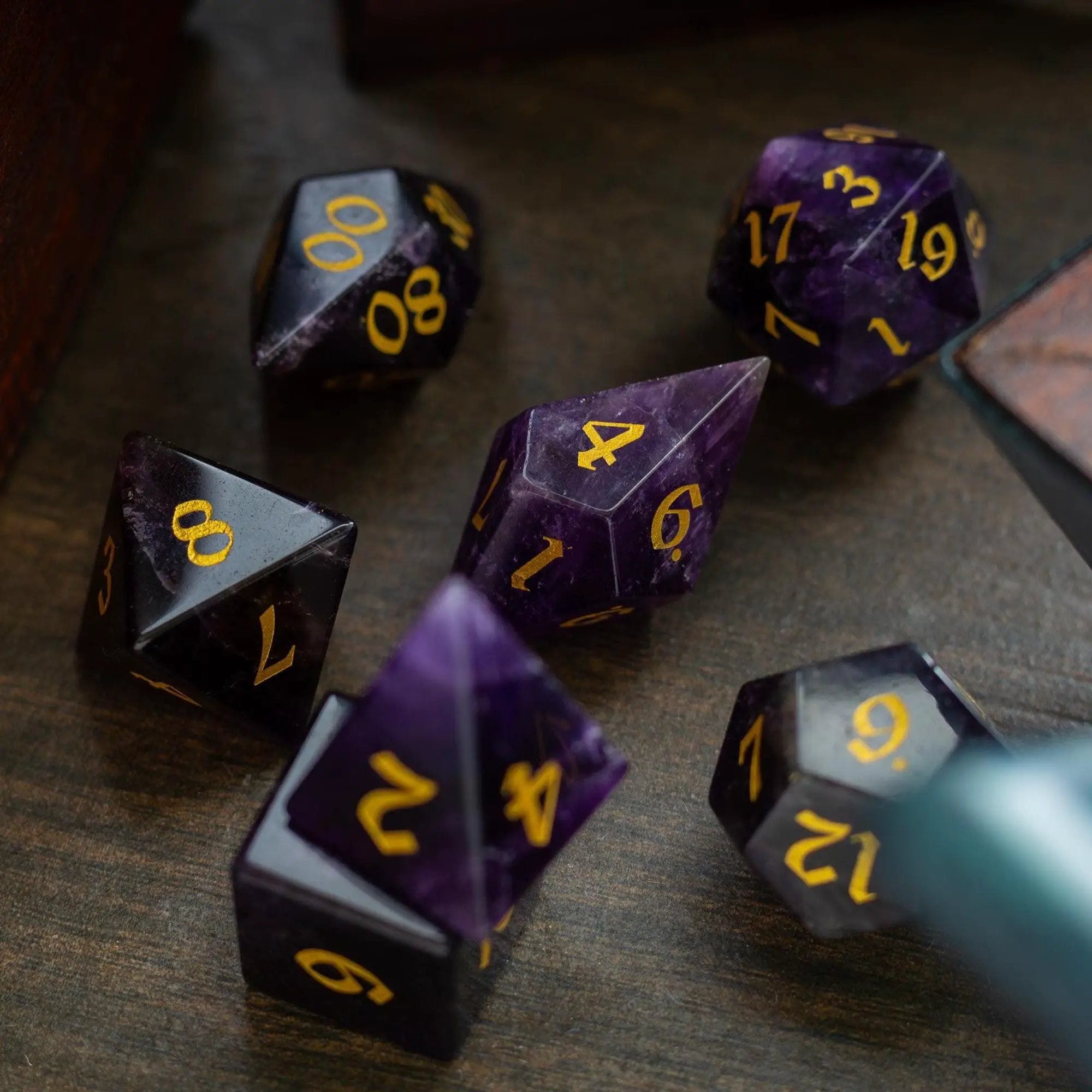 Purple amethyst gemstone DND dice set with elven cut design by Runic Dice, showcasing intricate facets and vibrant color.