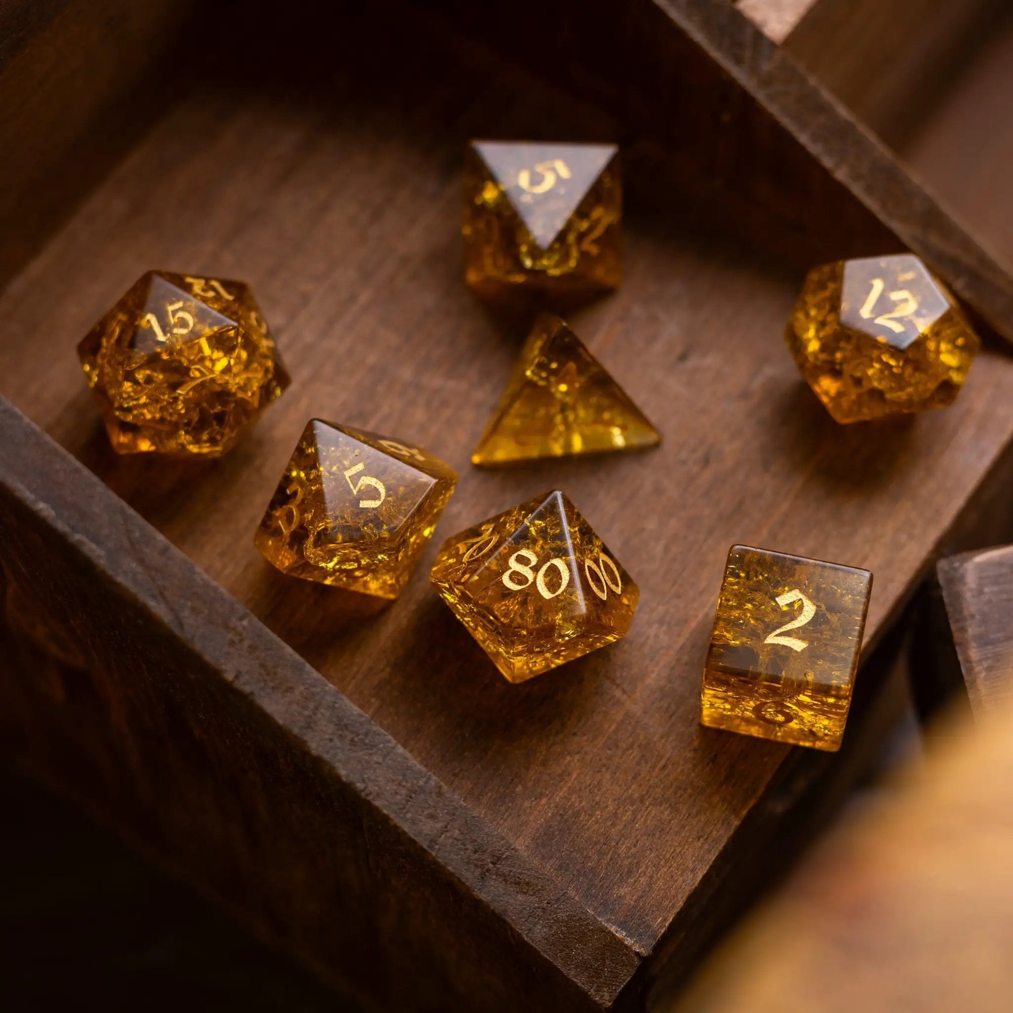 Gold honey lightning cracked glass gemstone DND dice set by Runic Dice, featuring intricate crack patterns and a shiny gold finish.