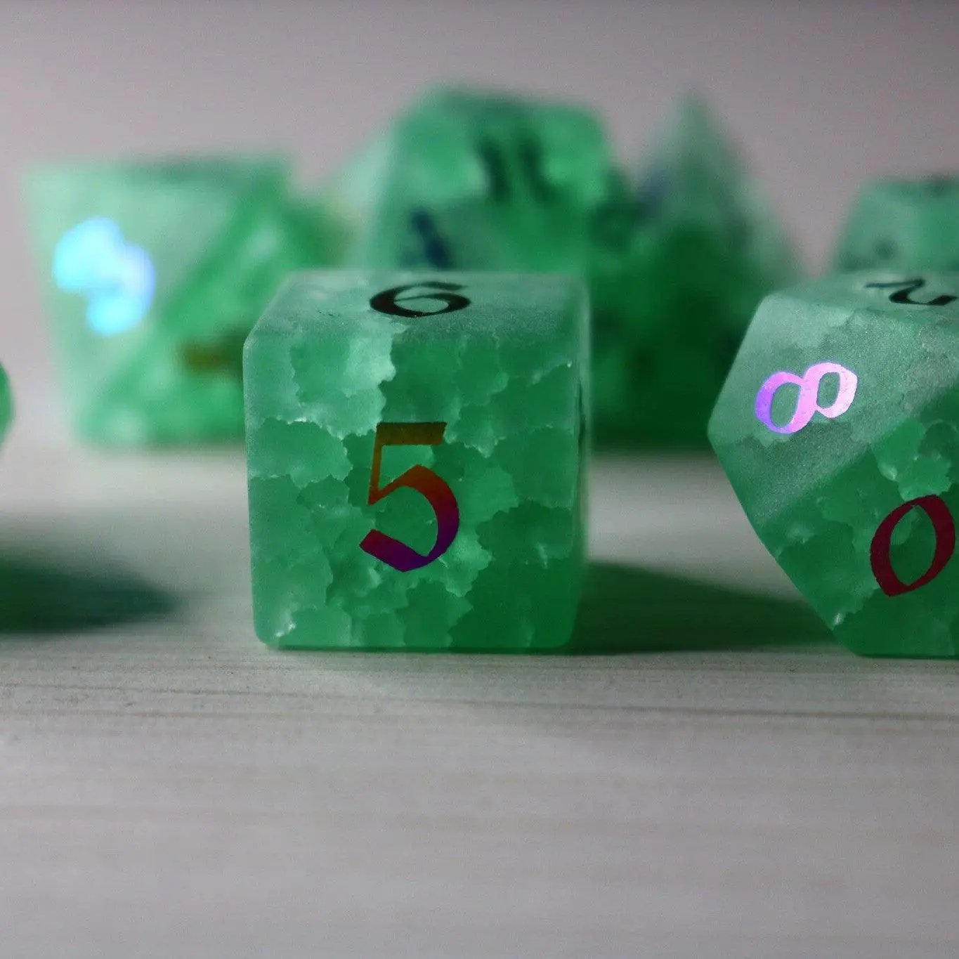 Green mint gemstone DND dice set with lightning crack pattern by Runic Dice, featuring inked numbers and a cracked glass design.