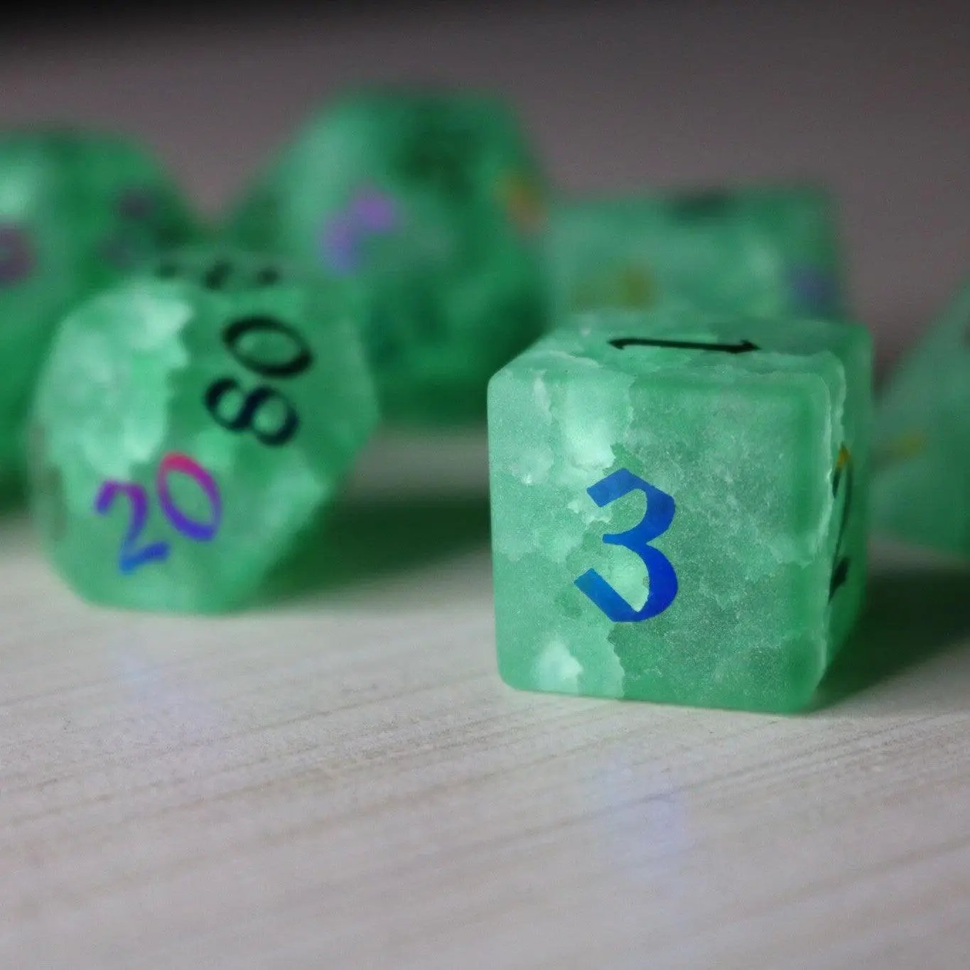 Green mint gemstone DND dice set with lightning crack pattern from Runic Dice, featuring inked numbers on glass material.
