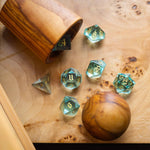 Hand-carved green water glass gemstone DND dice set by Runic Dice, featuring intricate carvings and vibrant green color.