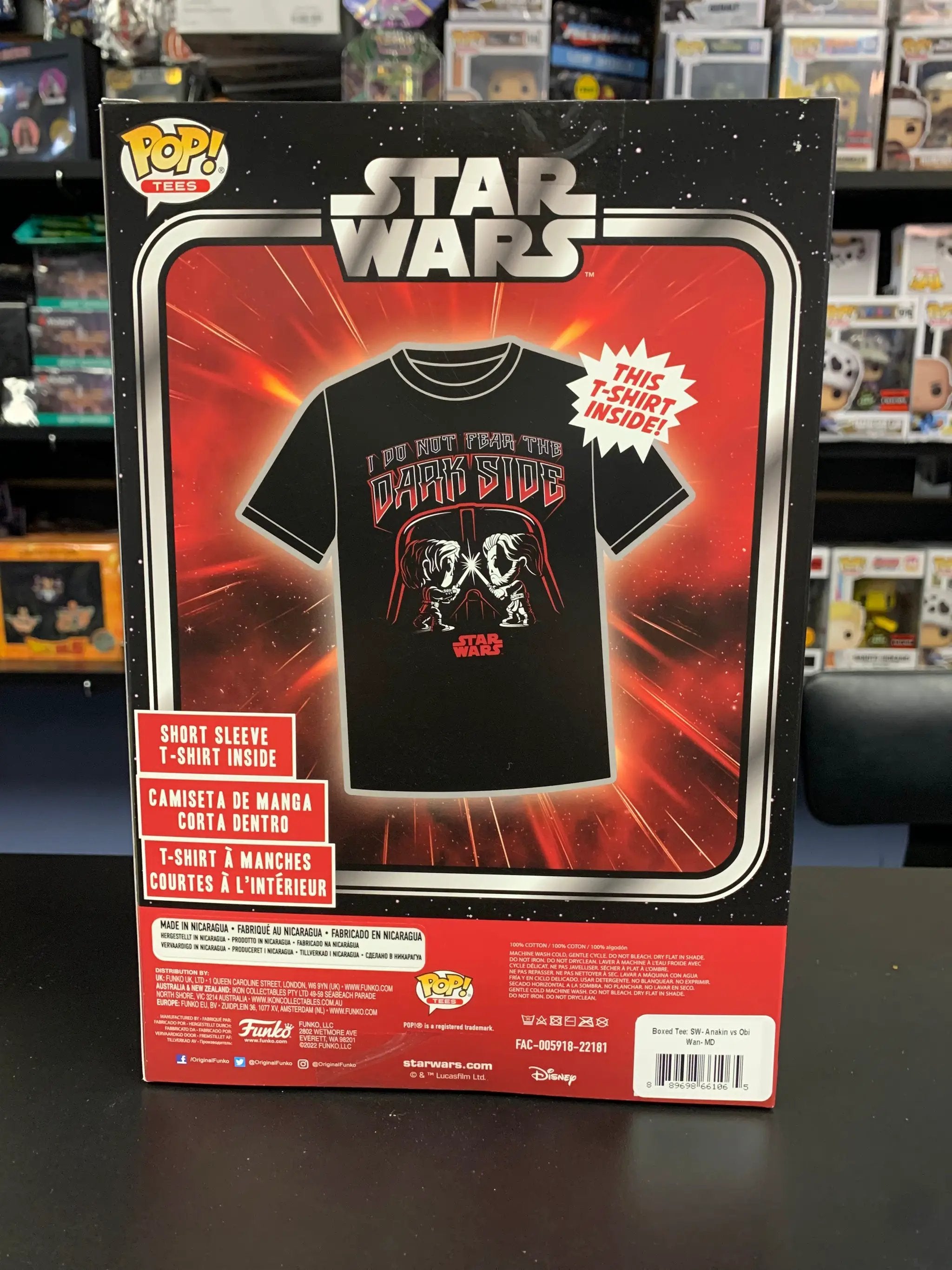 Boxed T-shirt featuring Anakin vs Obi-Wan design from THE MIGHTY HOBBY SHOP, displayed folded with visible graphic on the front.