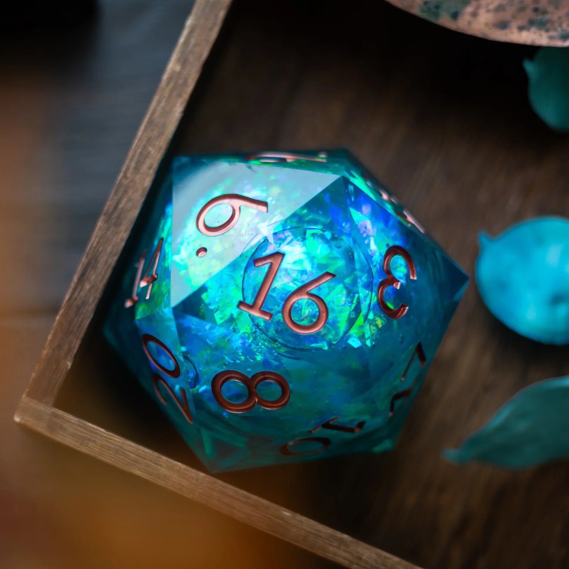 Sea green teal resin chonk dice with liquid core, handmade by Runic Dice, displayed alongside its box.