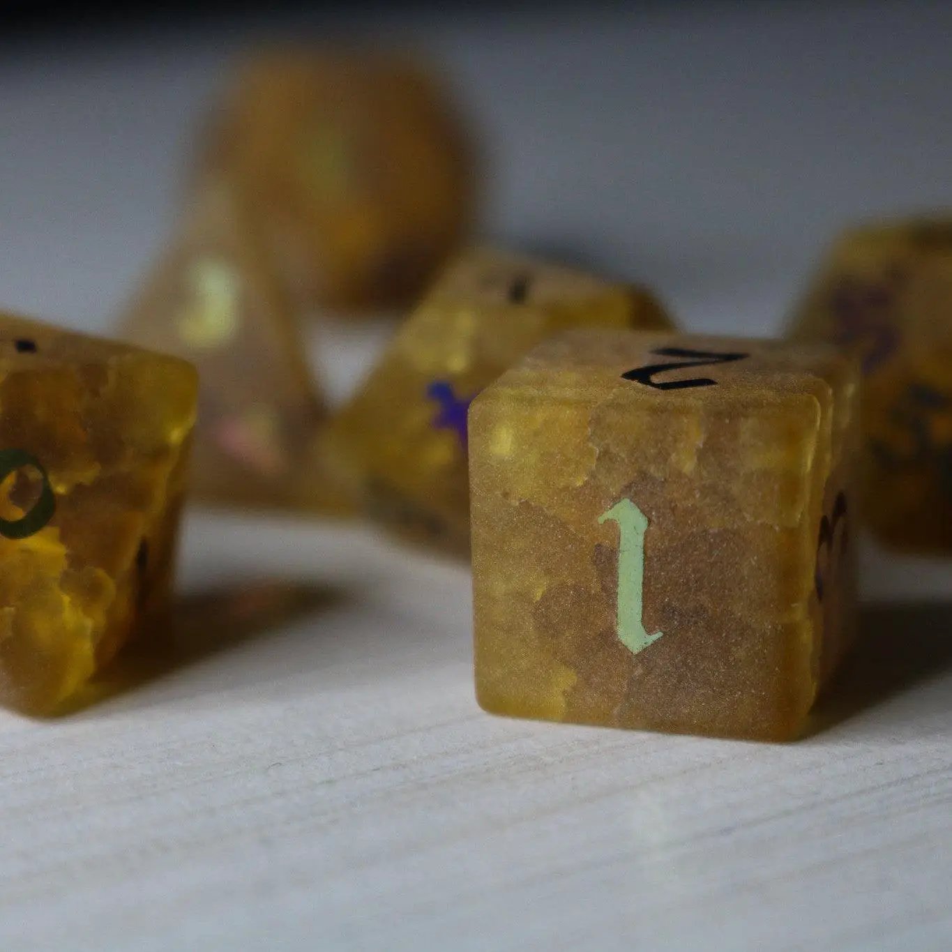Orange Halloween pumpkin themed gemstone DND dice set with inked lightning cracks by Runic Dice, featuring a cracked glass design.