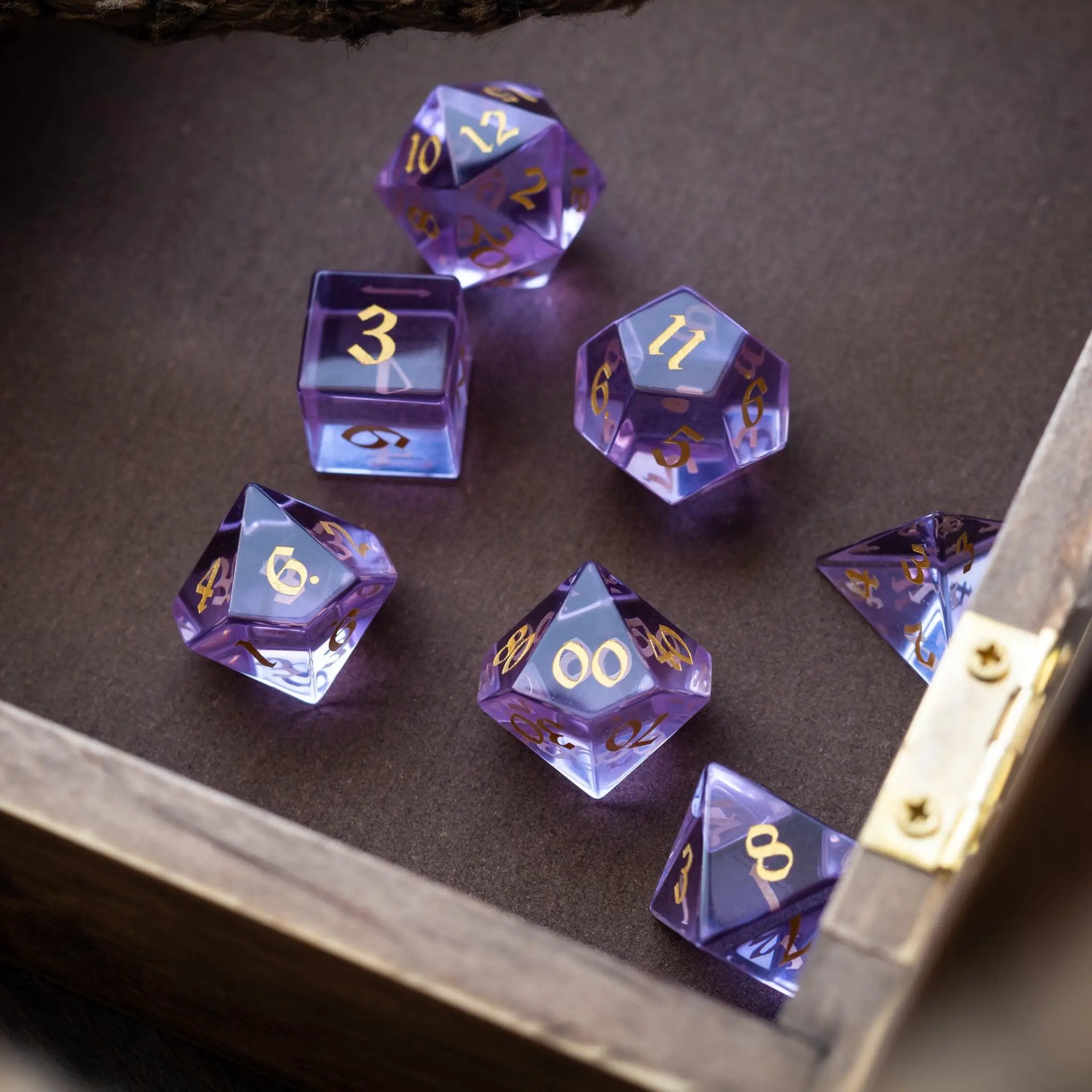 Purple zircon glass gemstone DND dice set with hand-carved design, featuring various shapes for tabletop role-playing games.