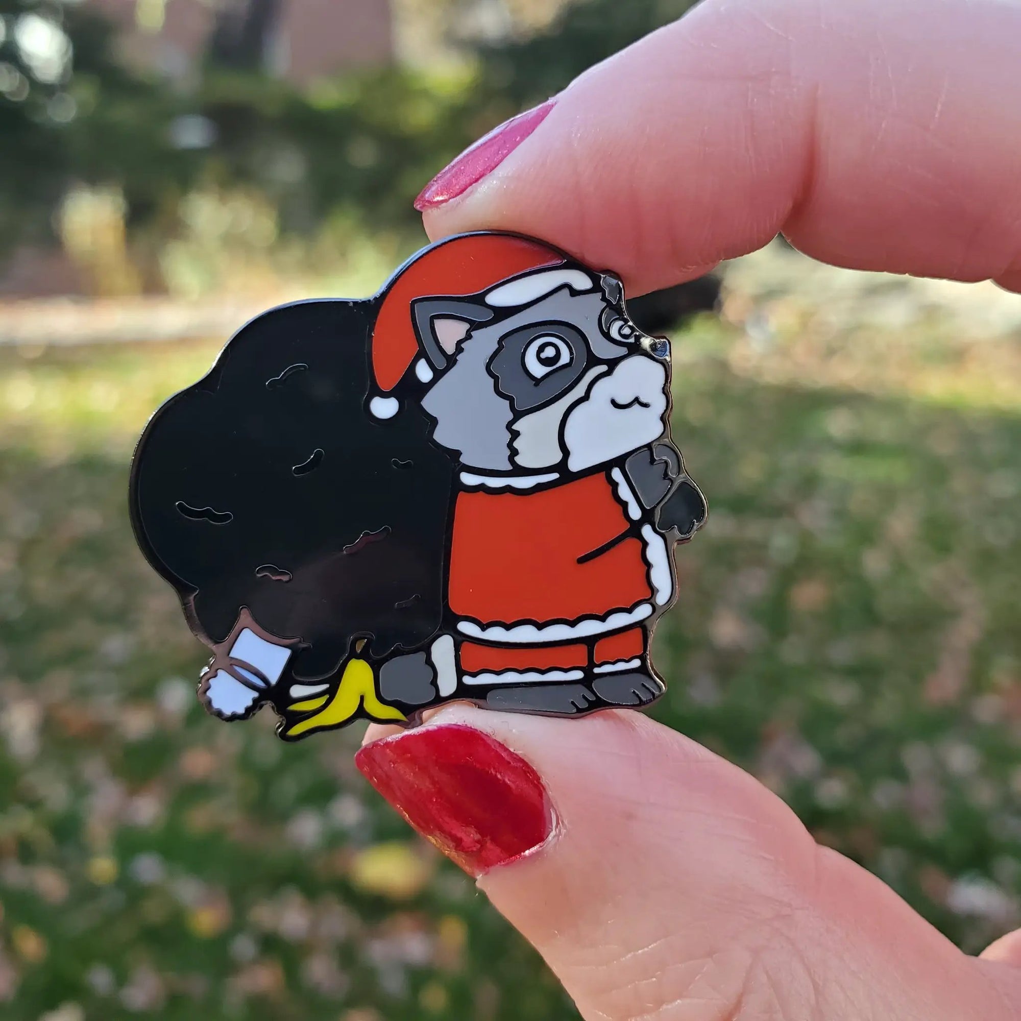 Kolorspun Raccoon Santa pin featuring a festive raccoon dressed as Santa Claus, perfect for holiday accessories and collectibles.