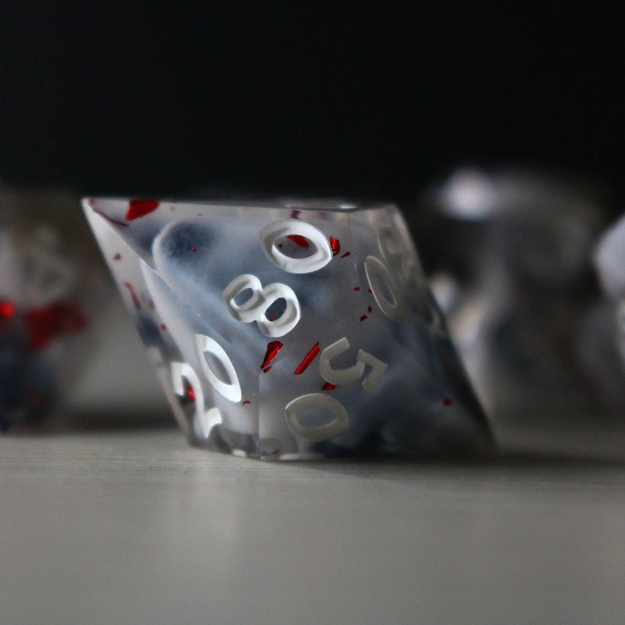 Smoke and Blood handmade resin DND dice set by Runic Dice featuring dark, smoky and blood-red color swirls in a detailed design.