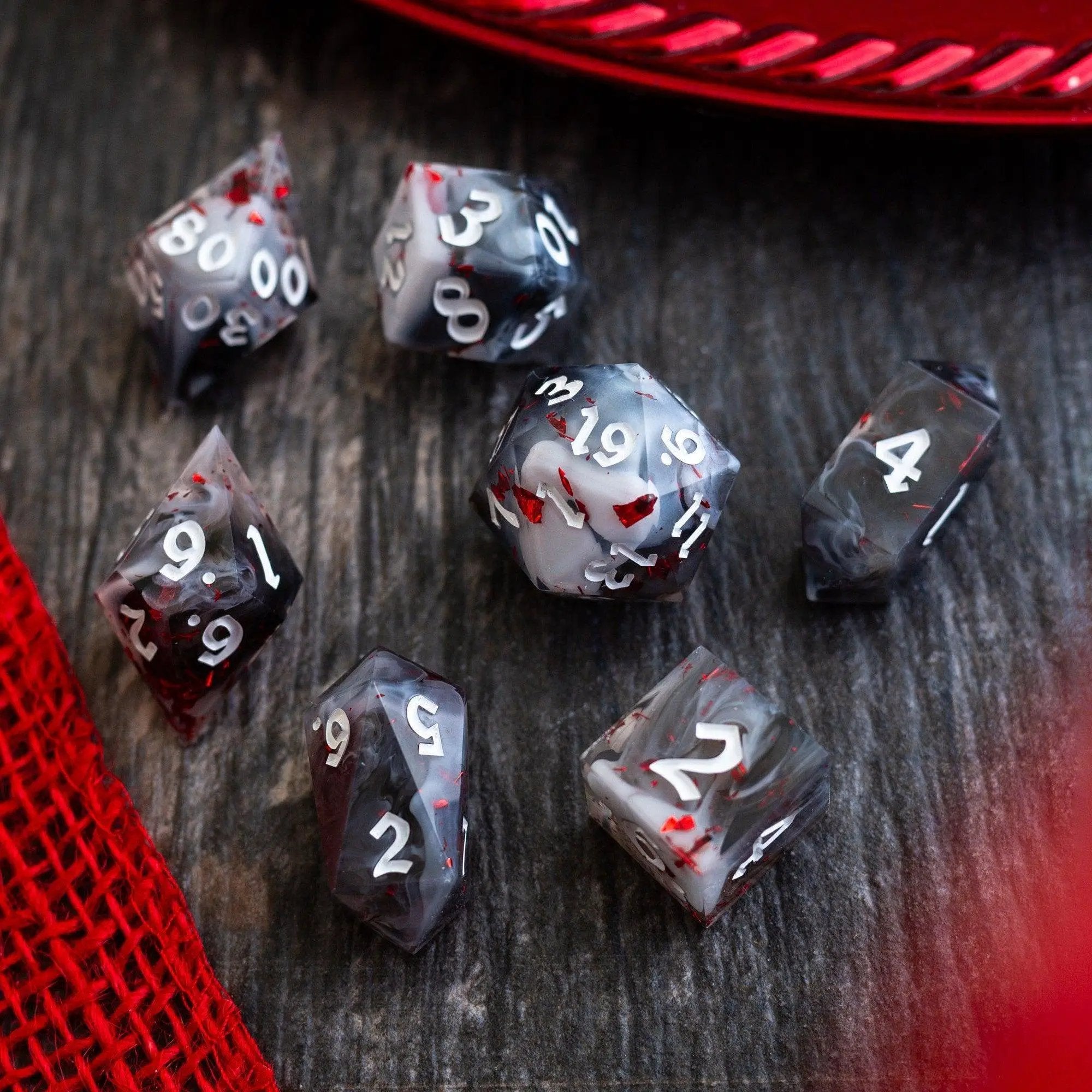 Smoke and Blood handmade resin D&D dice set featuring dark, smoky colors and intricate blood-red accents by Runic Dice.