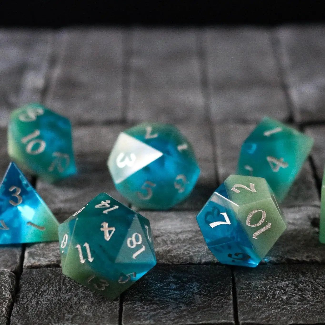 Hand-carved synthetic gemstone dice set in blue and green two-tone colors by Runic Dice, perfect for D&D gaming.