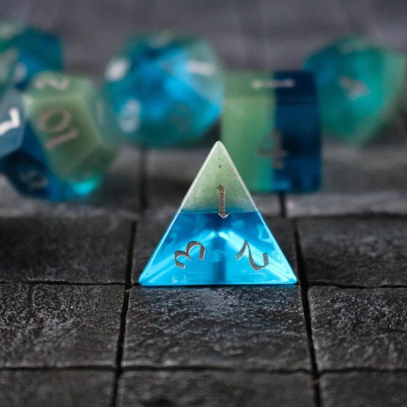 Hand-carved synthetic gemstone DND dice set by Runic Dice with two-tone blue and green colors for tabletop gaming.