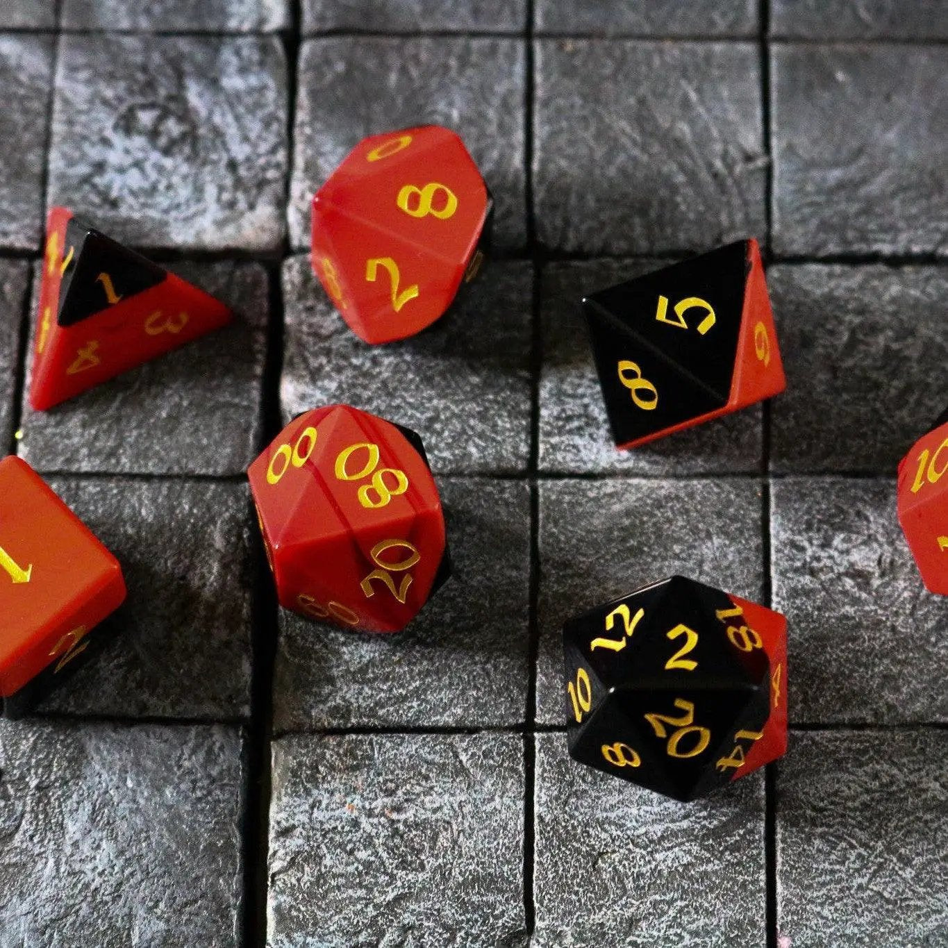 Runic Dice synthetic gemstone two-tone red and black hand-carved D&D dice set featuring intricate craftsmanship and vibrant colors.