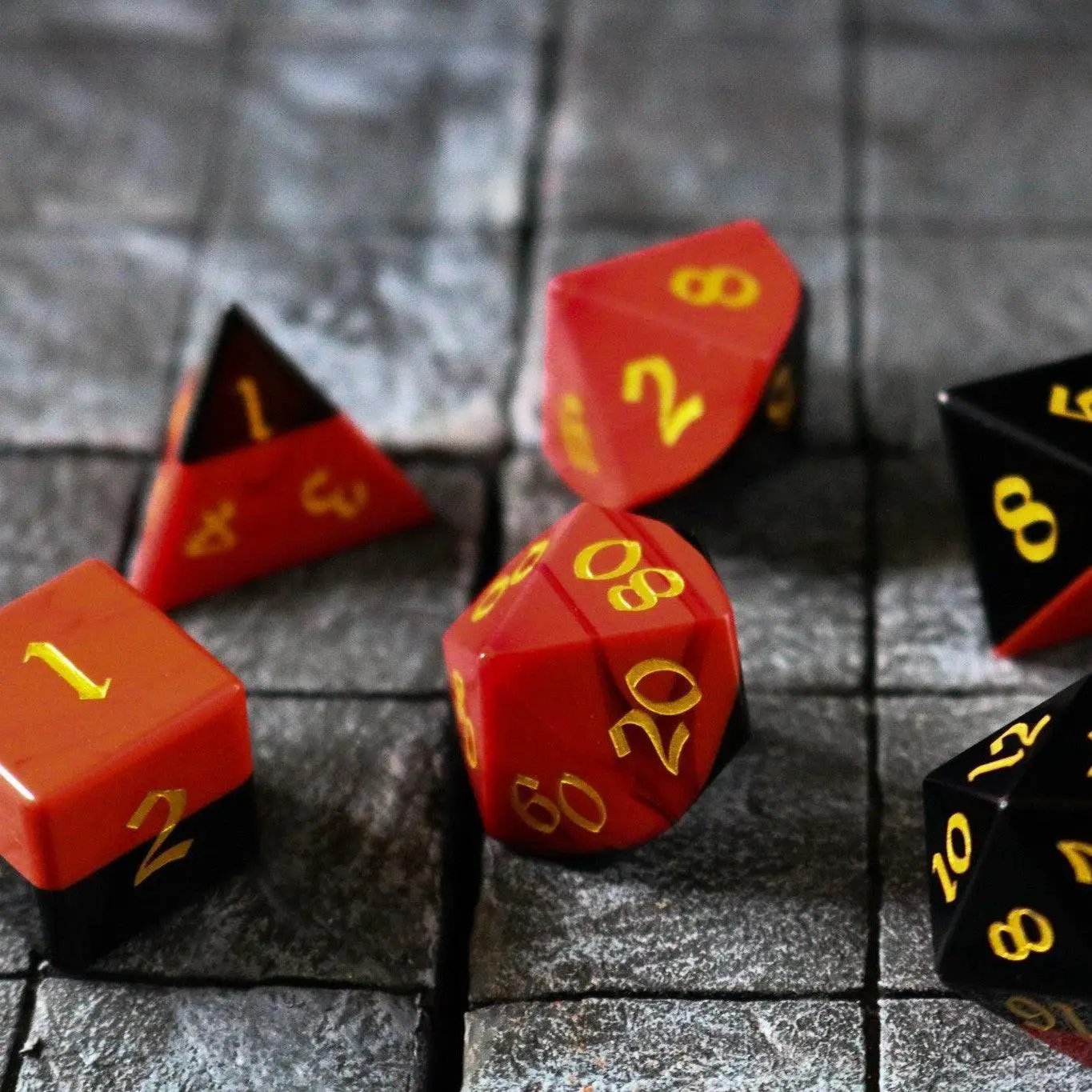 Synthetic gemstone two-tone red and black hand-carved DND dice set by Runic Dice featuring six-sided gemstone dice.