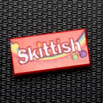 Custom printed LEGO Skittish candy 1x2 tile by B3 Customs, featuring detailed colorful candy design on LEGO brick.