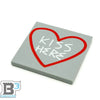 B3 Customs Kiss Here Road sidewalk art tile with white and red lettering on a concrete sidewalk surface.