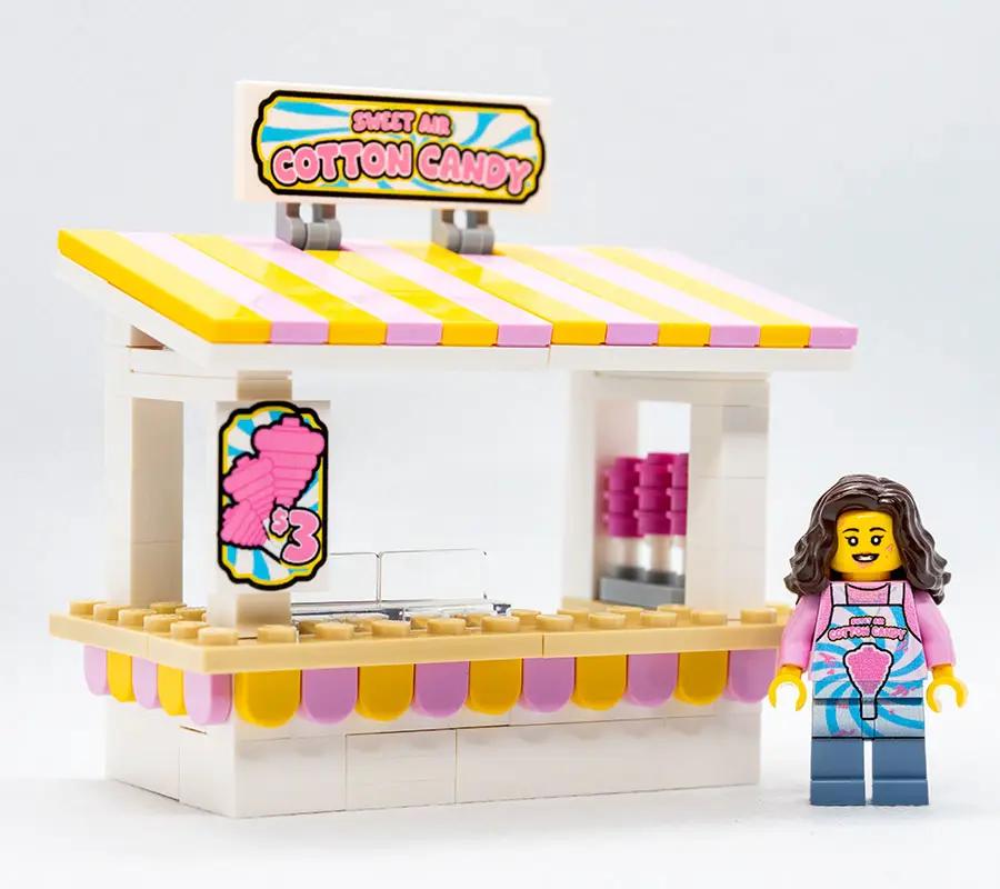 Lego cotton candy stand with Sweet Air branding and a minifigure employee, detailed colorful display for children's play.