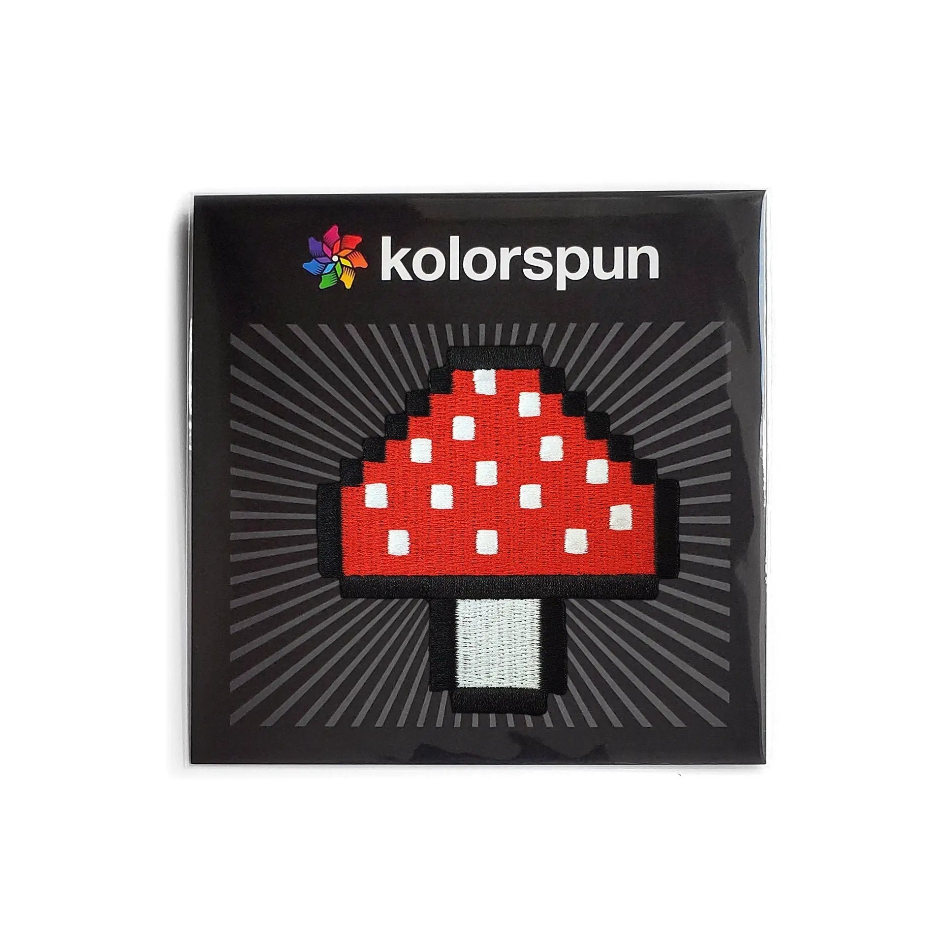 Kolorspun Pixel Mushroom Patch sewn on fabric, featuring a colorful pixelated mushroom design for clothing or accessories.