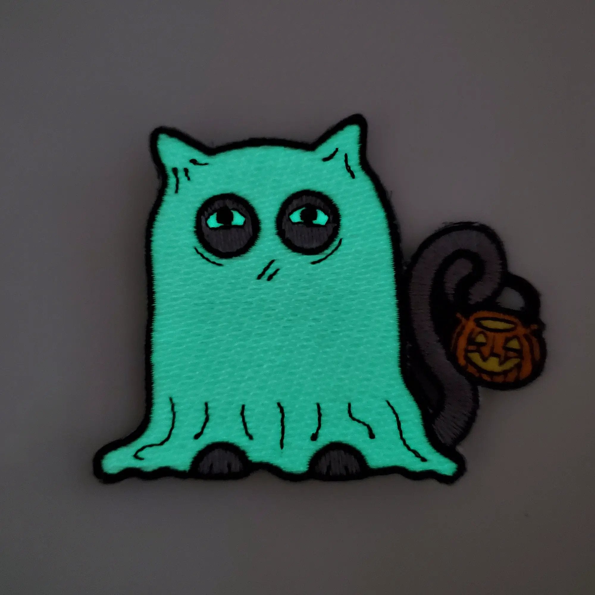 Glow-in-the-dark ghost cat patch by Kolorspun featuring a spooky, luminous design on fabric.