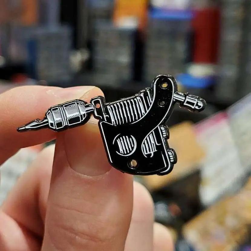 Kolorspun tattoo machine pin enamel pin featuring a detailed tattoo machine design, ideal for tattoo enthusiasts and collectors.