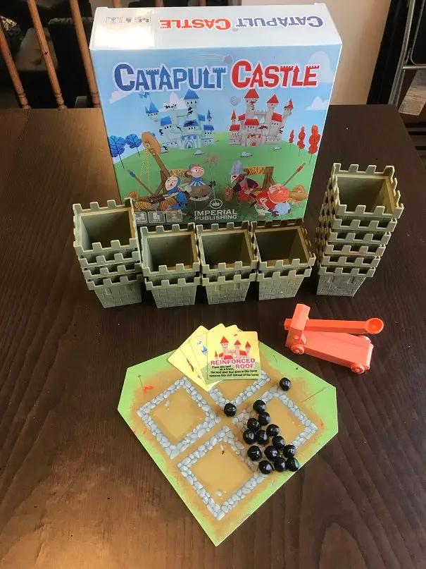 Mayday Games Catapult Castle medieval dexterity game components for 1-4 players, featuring colorful castle pieces and miniature catapults.