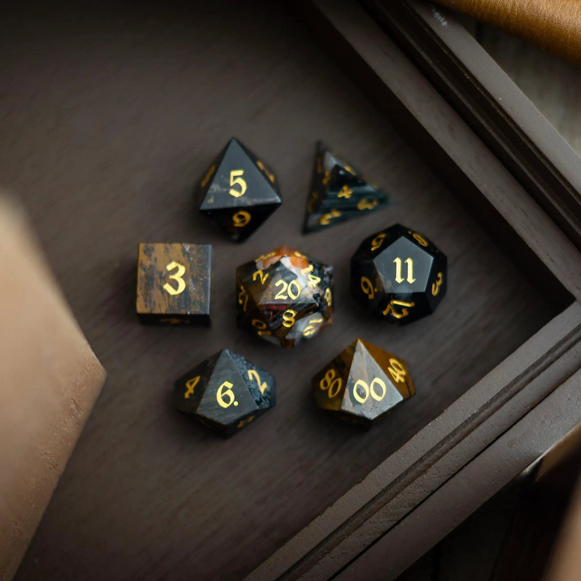 Black gemstone eagle eye DND dice set by Runic Dice, hand-carved gemstone dice with intricate eagle eye design for tabletop gaming