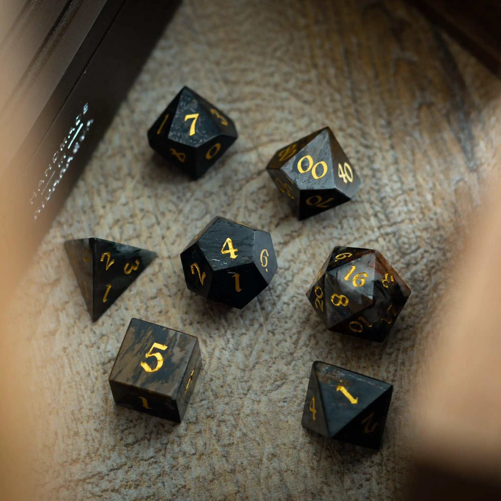 Black gemstone eagle eye DND dice set by Runic Dice featuring hand-carved design and detailed eagle eye pattern.