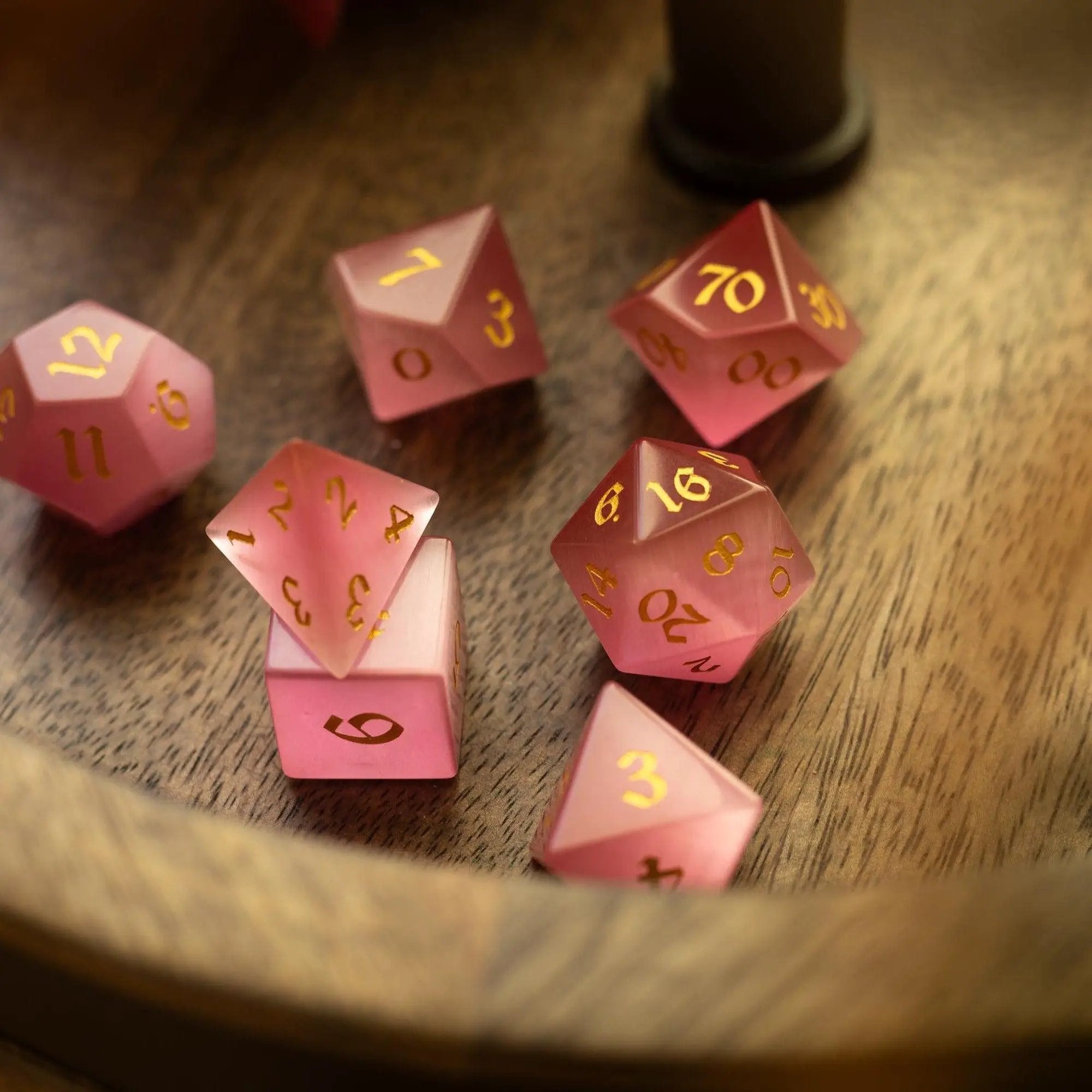 Hand-carved gemstone pink watermelon cats eye DND dice set by Runic Dice, featuring vibrant pink and green stone details.