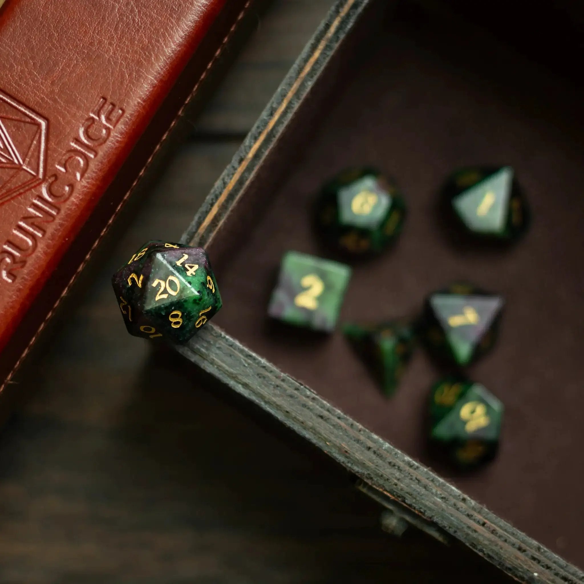 Zoisite gemstone polyhedral D&D dice set by Runic Dice with colorful, polished gemstone faces and engraved numbers.