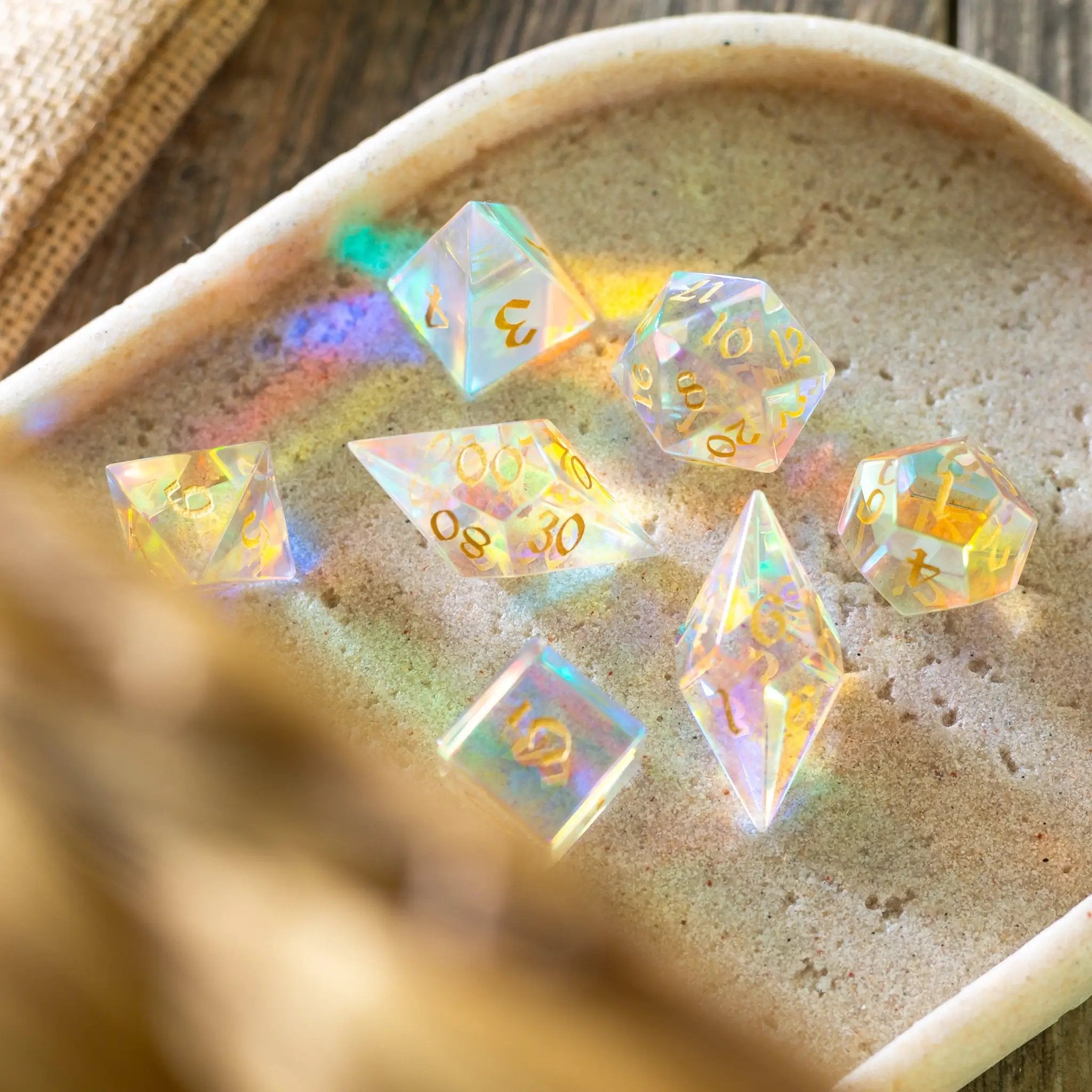 Set of gemstone dichroic glass Elven cut D&D dice from Runic Dice featuring colorful, reflective gemstone gemstone surfaces.